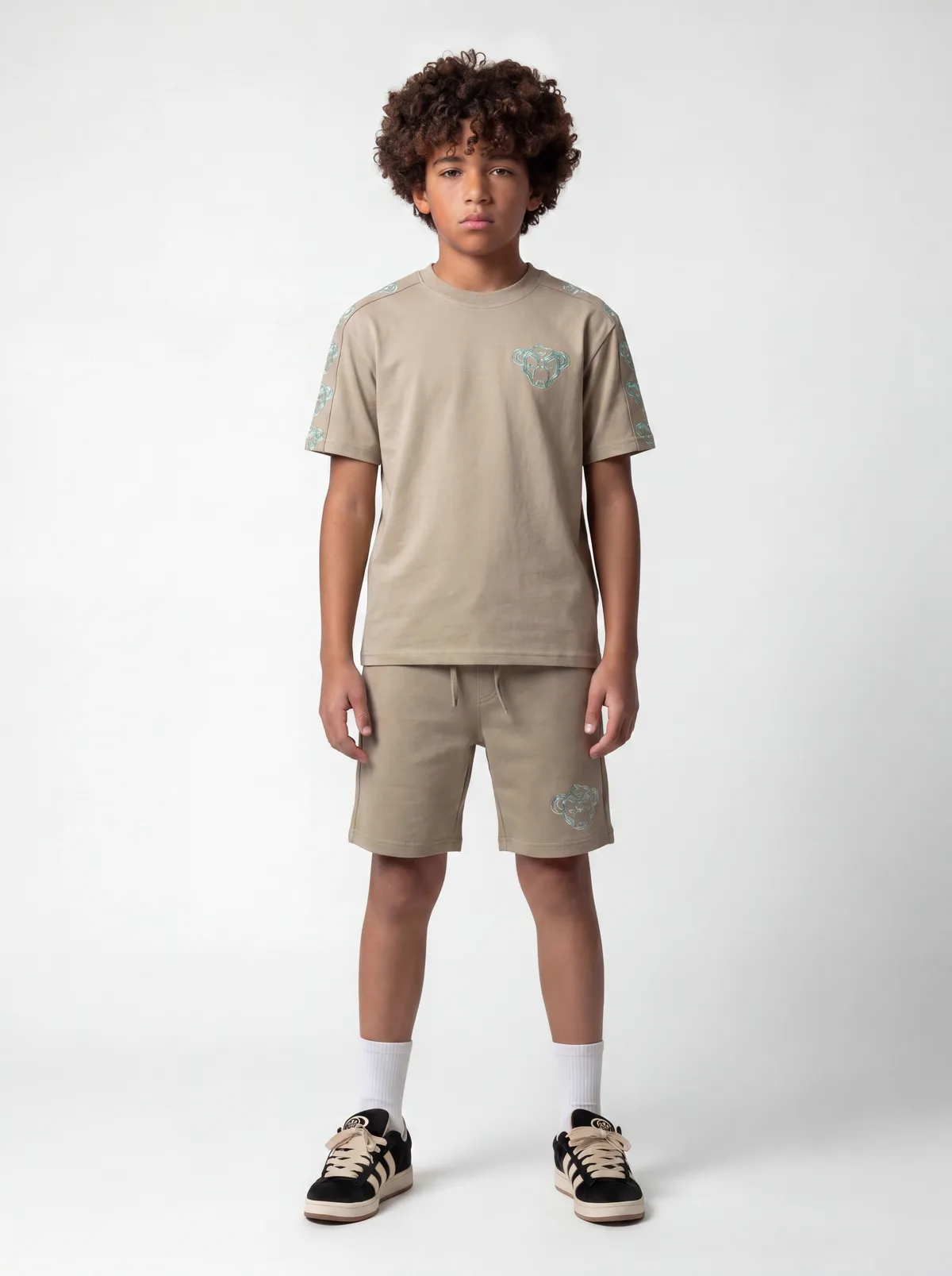 Black Bananas beige panther-embroidery chest tee with sleeve-tape print and matching shorts on AI young model in clean white studio