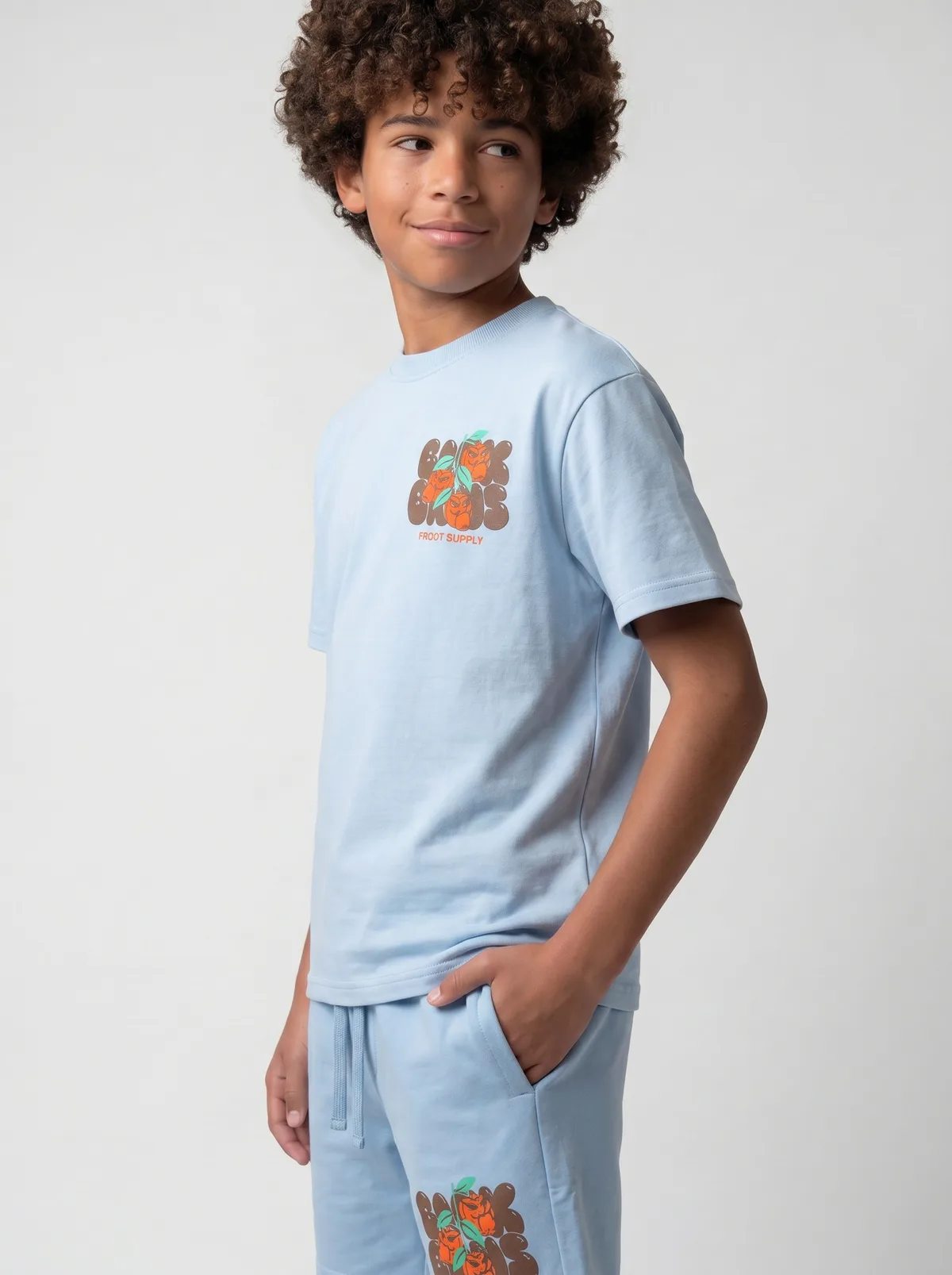 Black Bananas light blue Fruit Supply twinset three-quarter smiling pose on AI young model in clean studio