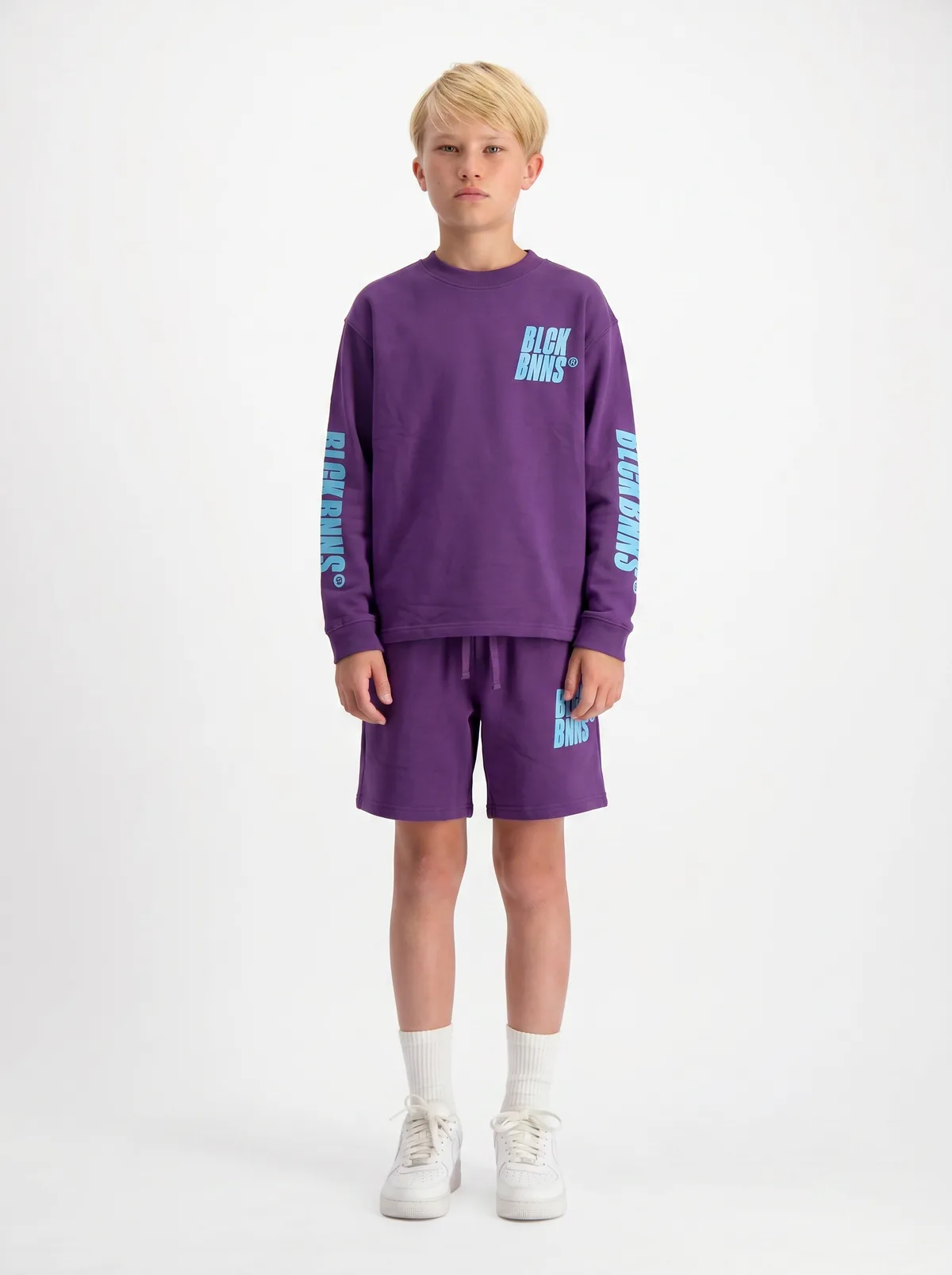 Black Bananas purple BLCK BNNS sleeve-print kids long-sleeve and shorts twinset on AI young model in clean white studio, full-length front pose