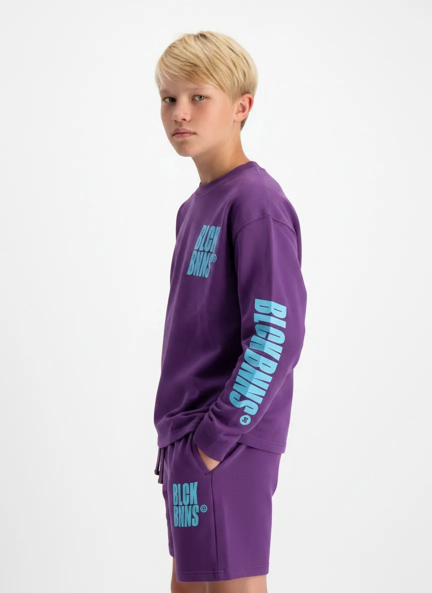 Black Bananas purple BLCK BNNS twinset hands-in-pocket calm pose on AI young model in clean white studio