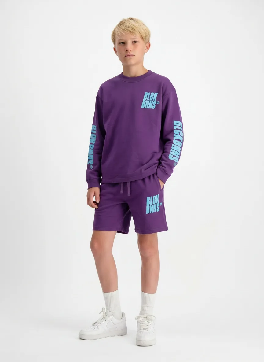 Black Bananas purple long-sleeve and shorts back full-body on AI young model in clean studio