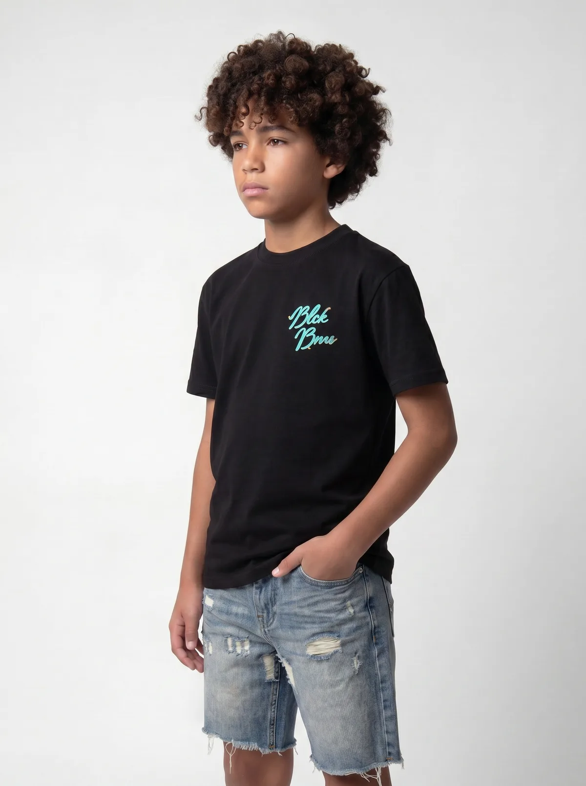 Black Bananas black Blck Bnns turquoise script-logo tee with light denim shorts hand-in-pocket pose on AI young model in clean white studio