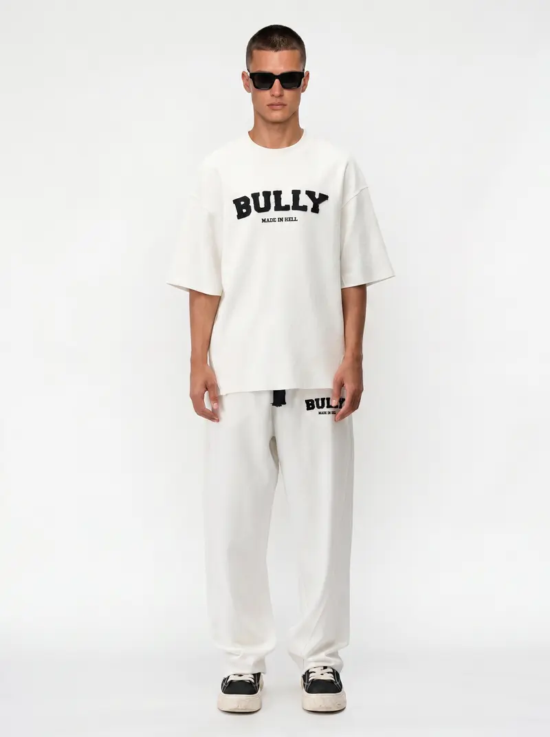 Bully Made In Hell cream oversized tee with matching cream sweatpant, straight-on front, on an AI male model in black sunglasses