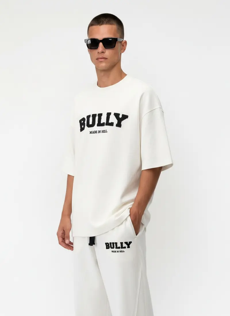 Bully Made In Hell cream co-ord set, three-quarter frame, on an AI male model