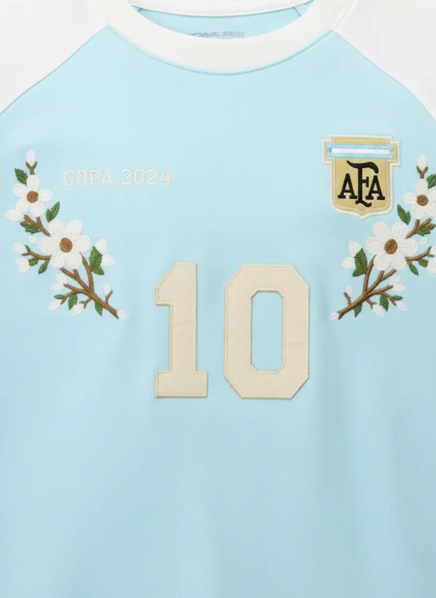 Bully Essence Club sky blue raglan chest macro showing the Argentina-style crest and appliqué number 10