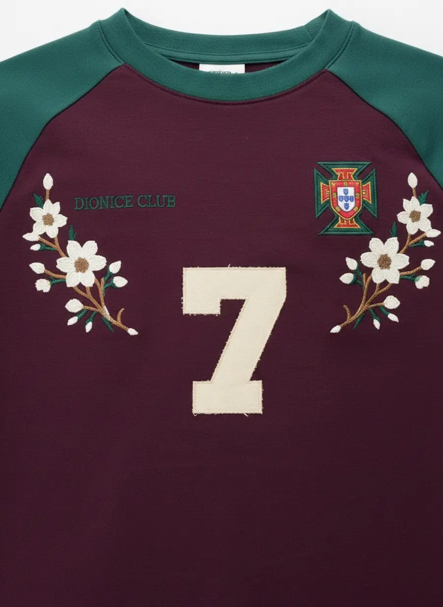 Bully Essence Club plum raglan chest macro showing the crest and appliqué number 7 with floral embroidery