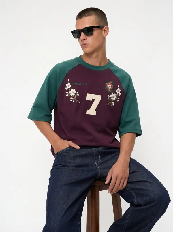 Bully Essence Club plum and green raglan tee, seated editorial pose