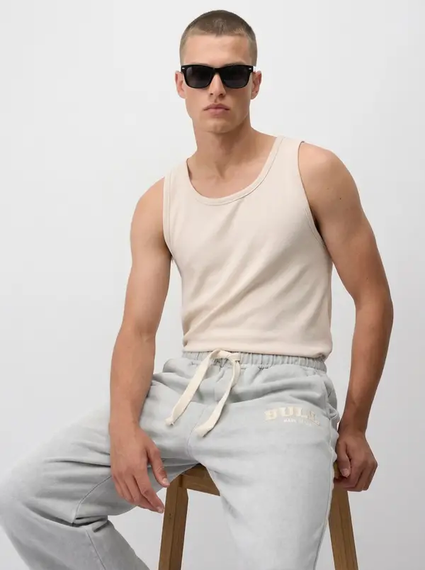 Bully heather grey wordmark sweatpant, seated editorial pose with a ribbed tank