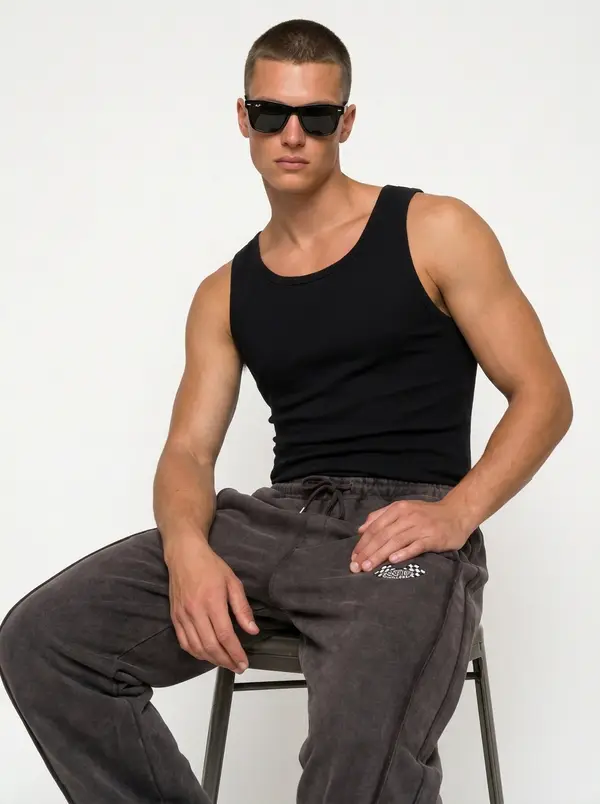 Bully charcoal checkered-flag sweatpant, seated editorial pose with a black tank