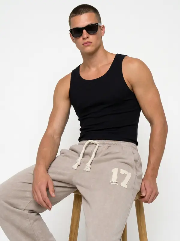 Bully sand checkered-flag sweatpant with an appliqué 17, seated editorial pose