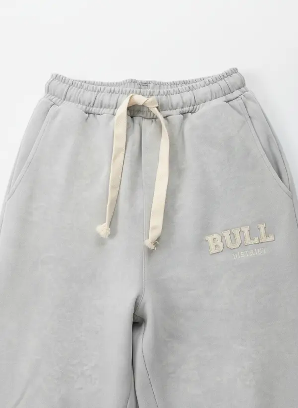 Bully heather grey wordmark sweatpant waistband detail macro showing the drawcord and embroidered wordmark