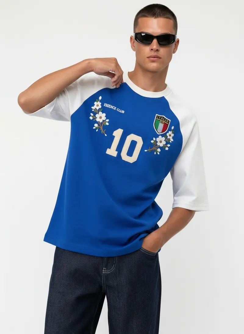 Bully Essence Club raglan tee in royal blue with white sleeves, alternate editorial pose, on an AI male model