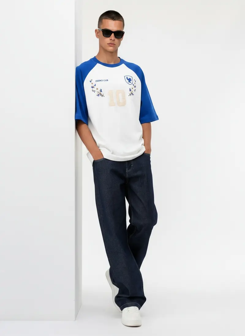 Bully Essence Club raglan tee in white with royal blue sleeves and an embroidered rooster crest, on an AI male model