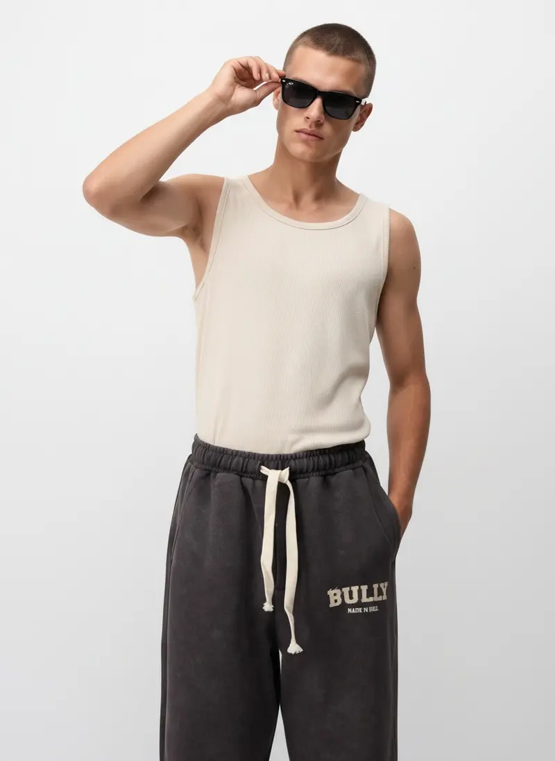 Bully wordmark sweatpant in espresso acid wash with a ribbed tank, on an AI male model
