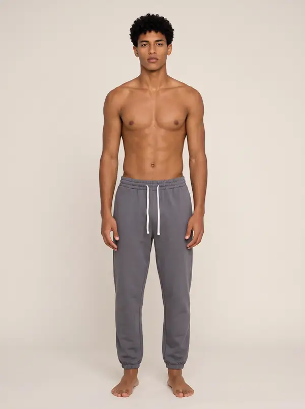 Future Homme graphite jogger, front full length, on the second AI muse in a warm neutral studio