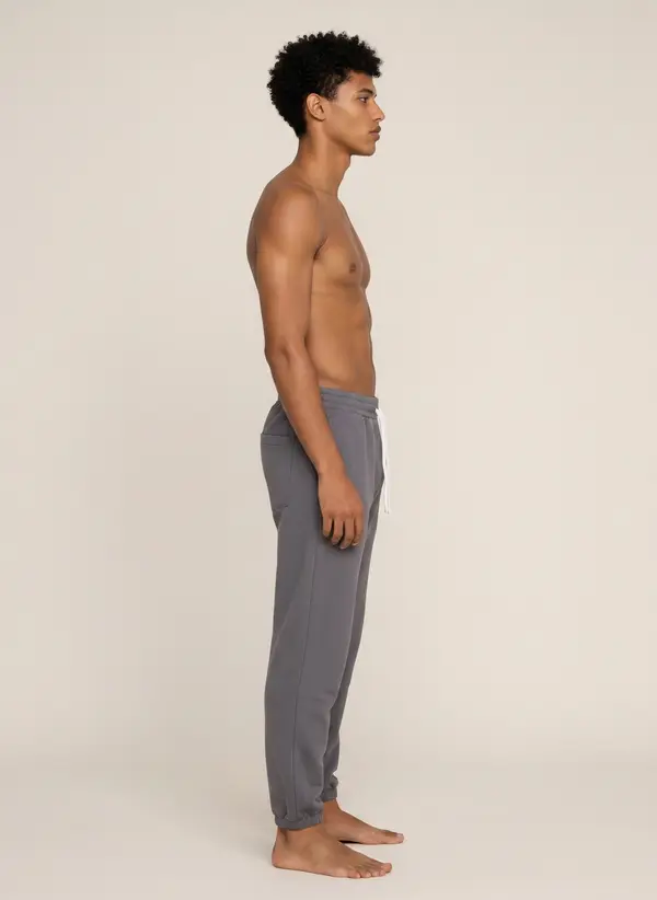 Future Homme graphite jogger, side profile showing tapered leg and cuff, on the second AI muse