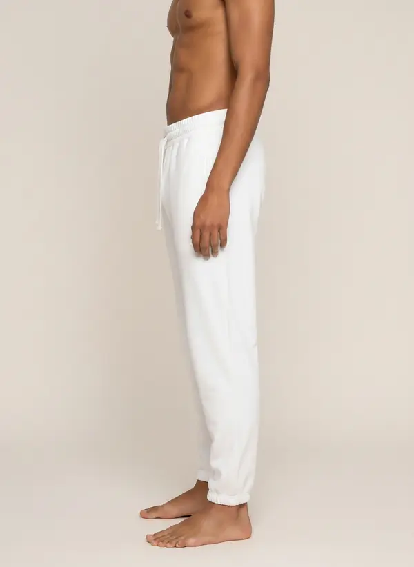 Future Homme ivory jogger, side profile, on the second AI muse in a warm neutral studio