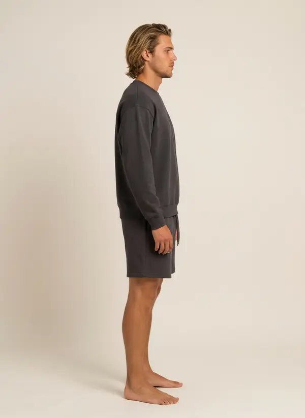Future Homme graphite crew and short set, side profile, on an AI male model in a warm studio