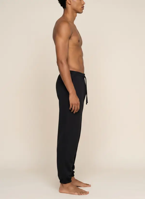 Future Homme navy jogger, side profile, on the second AI muse in a warm neutral studio