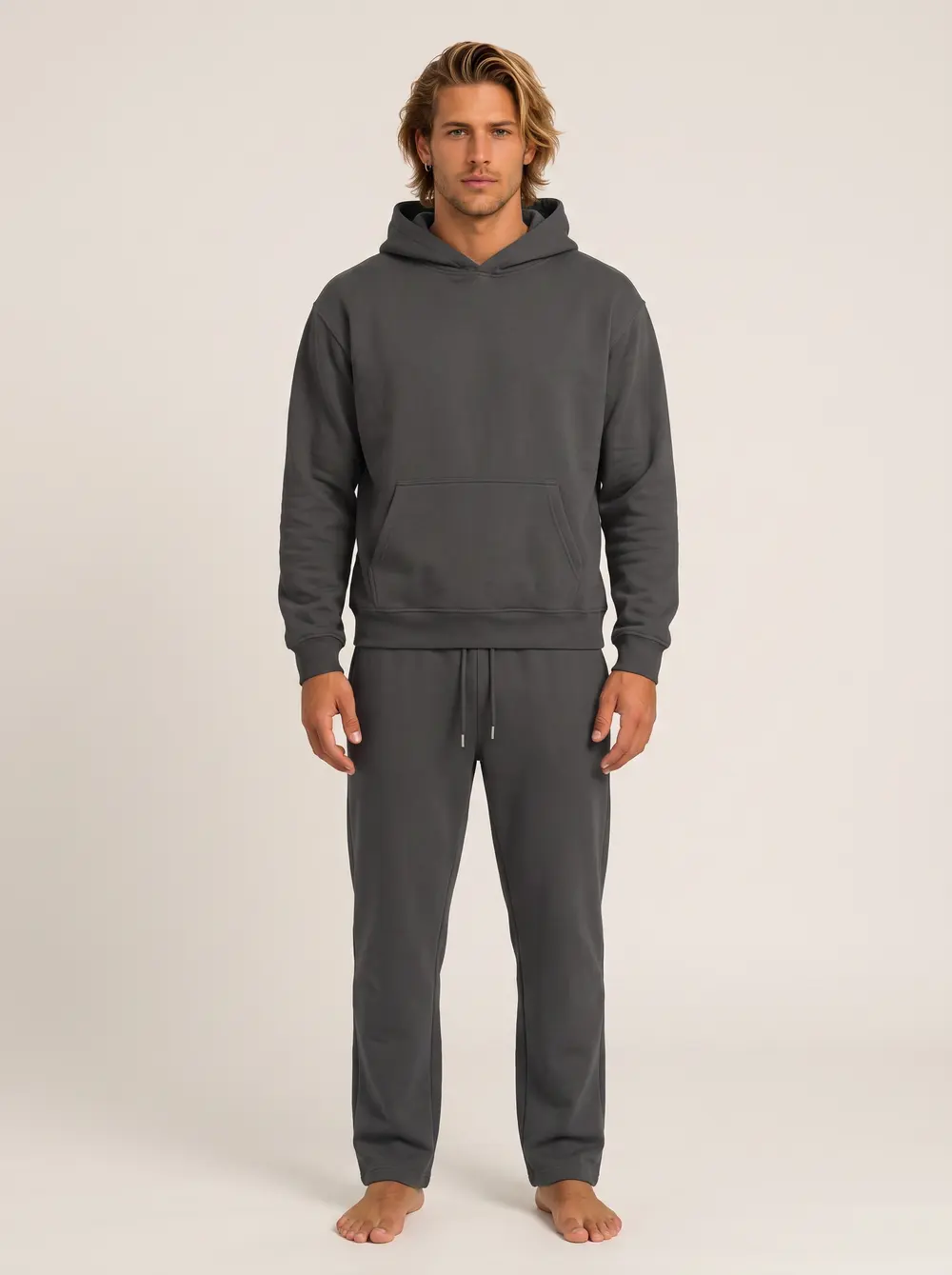 Future Homme graphite hooded sweatshirt and matching jogger on an AI male model, straight-on front, warm neutral studio