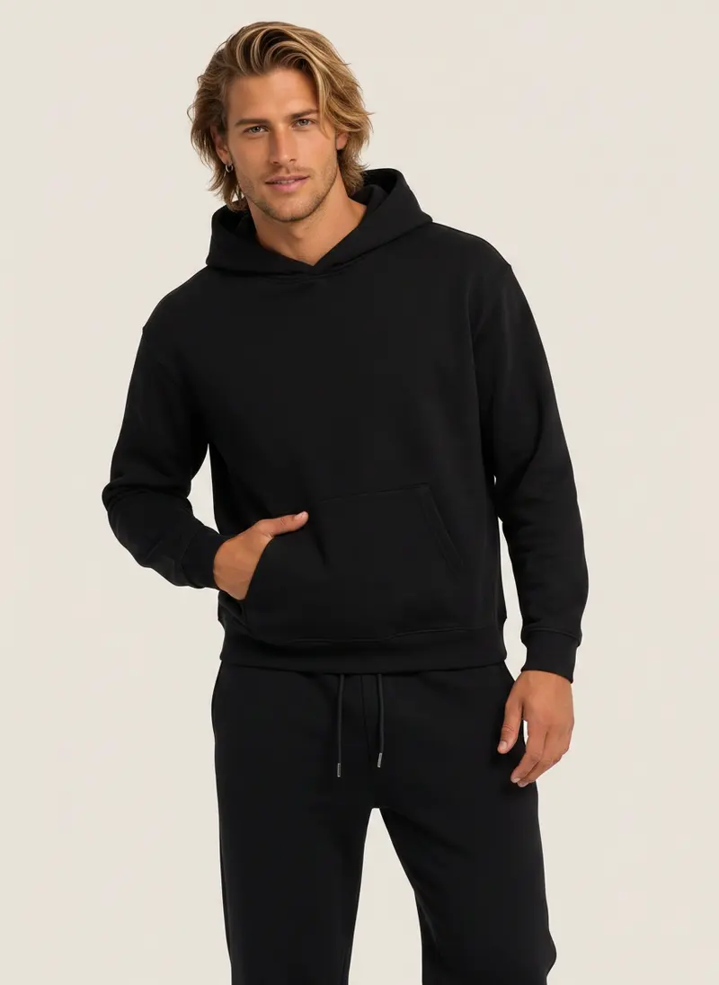 Future Homme black hooded sweatshirt and matching jogger on an AI male model, three-quarter frame with hand in pocket
