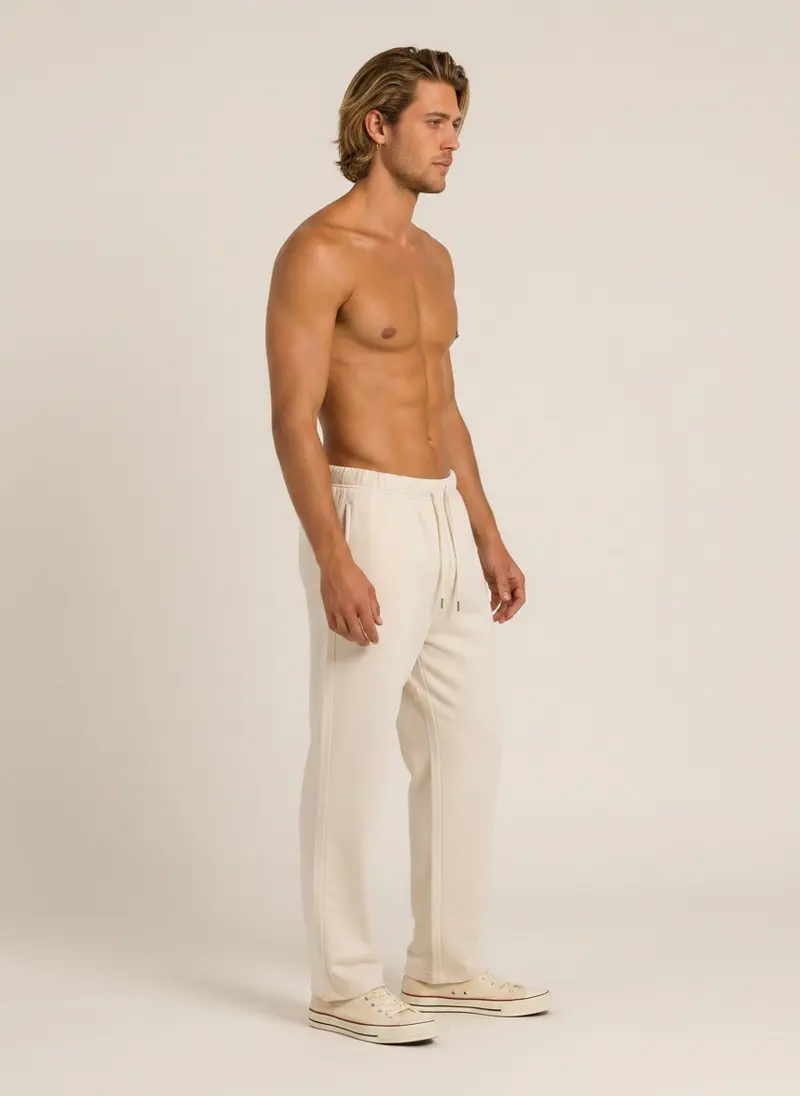 Future Homme cream wide lounge pant shot bare-chest, three-quarter frame, on an AI male model in a warm studio