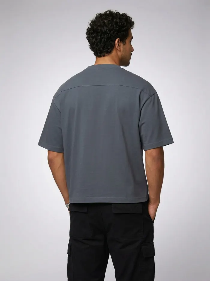 Godzeal Basics slate-blue dove-logo tee chest-print detail crop on AI male model in clean studio
