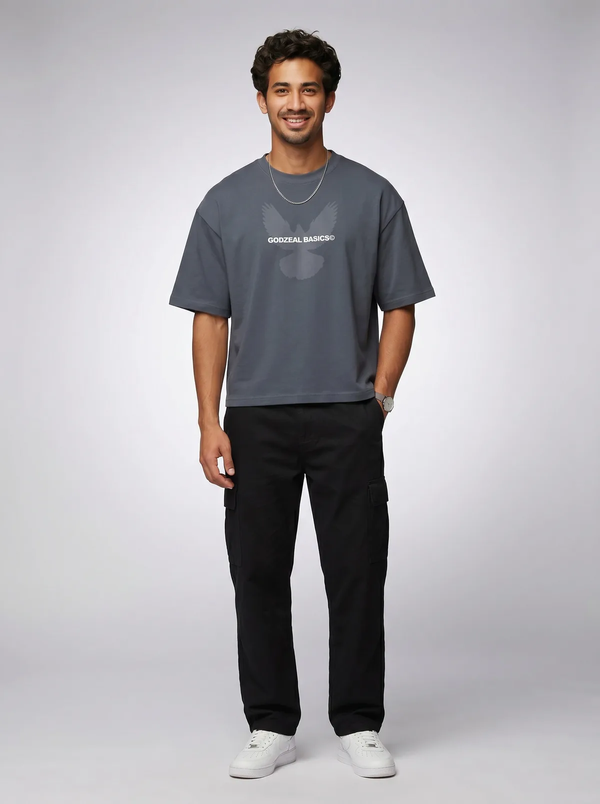 Godzeal Basics dove-logo slate blue oversized tee on AI male model with curls and silver chain in clean studio