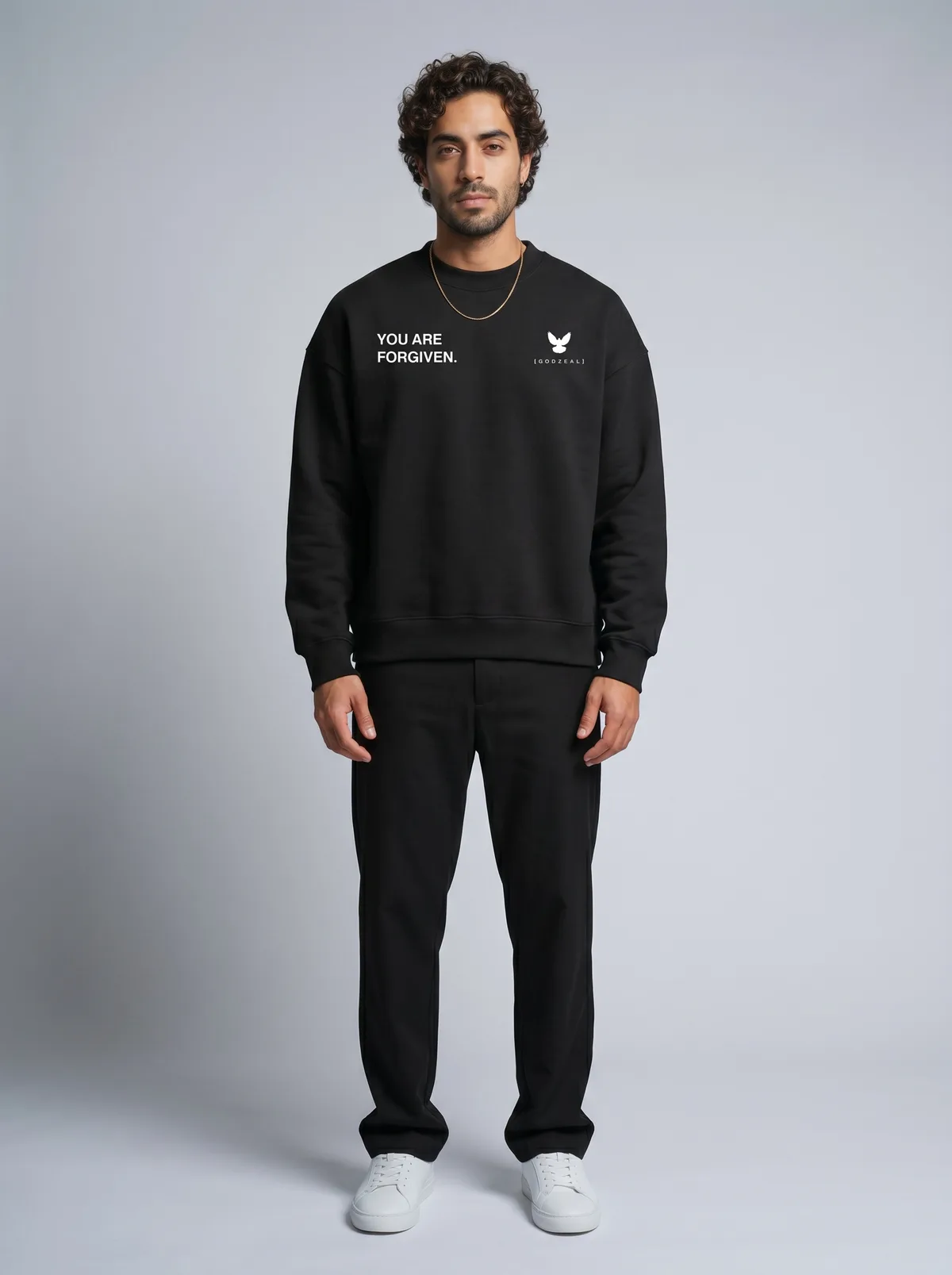 Godzeal YOU ARE FORGIVEN black crewneck sweater on AI male model with curly hair and gold chain in clean American studio