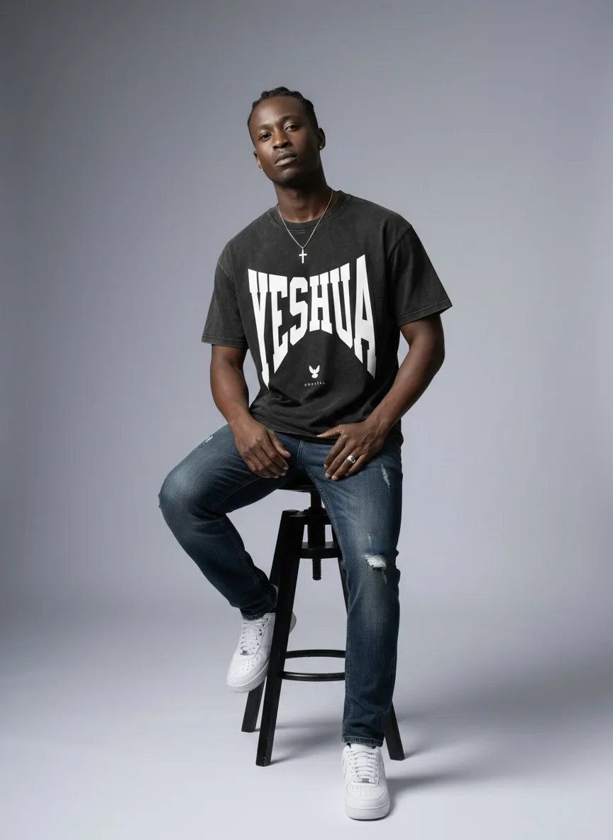Godzeal YESHUA tee seated pose on AI male model with relaxed posture in clean American studio