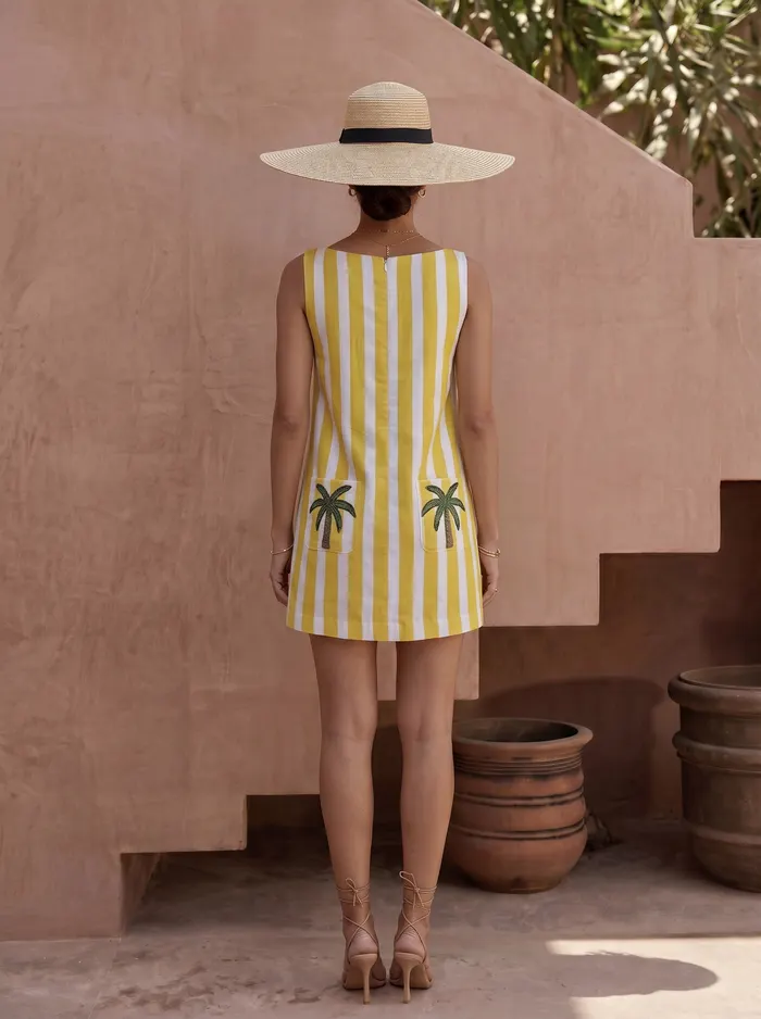 Maison Blu yellow stripe palm-pocket dress back view with wide-brim straw hat on AI model in Marrakech courtyard
