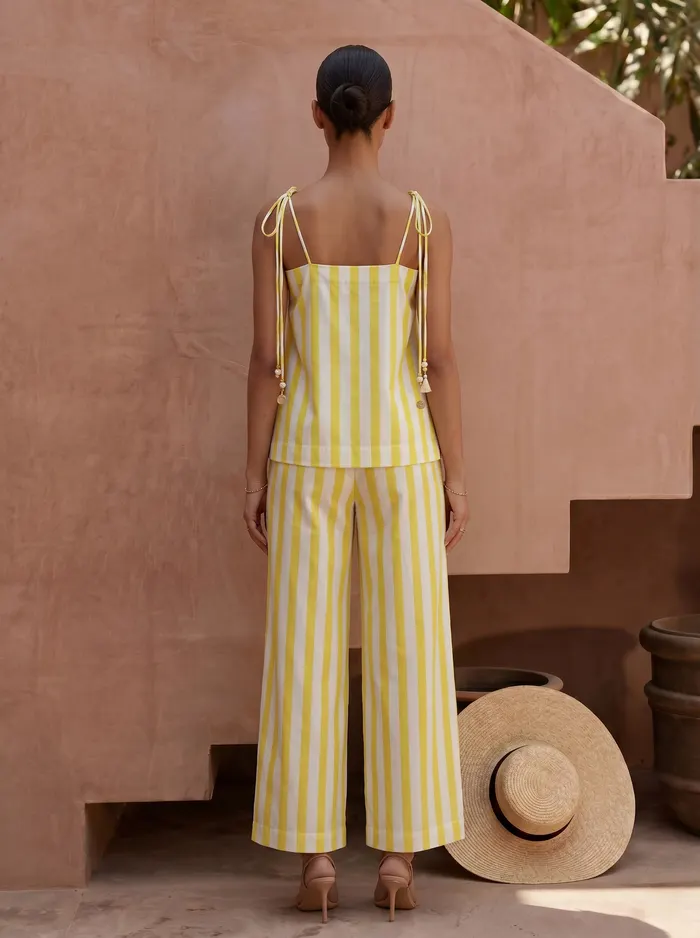 Maison Blu yellow stripe palm halter and wide-leg trouser set back view on AI model in Marrakech courtyard