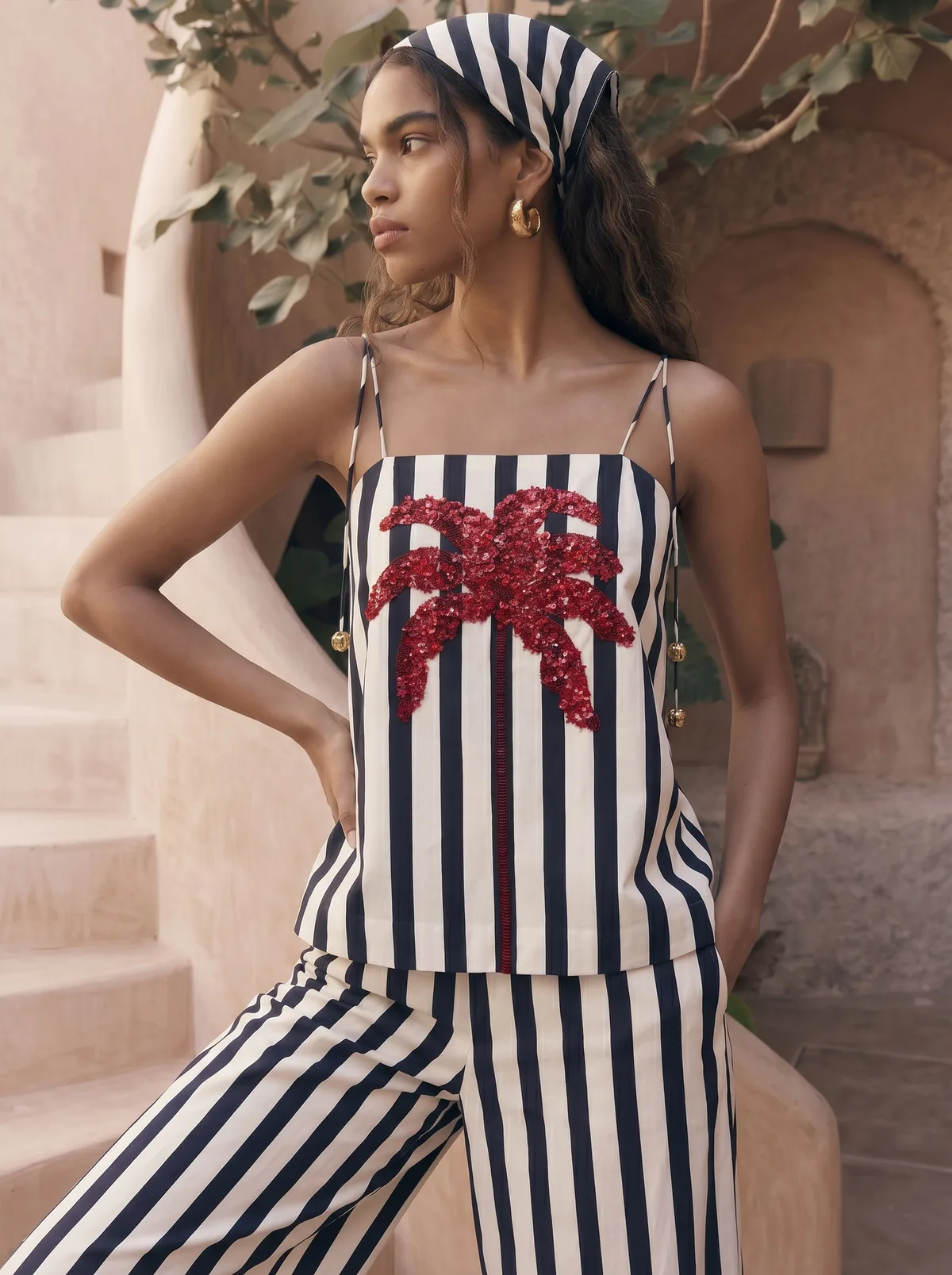 Maison Blu navy stripe red-sequin starfish cami top three-quarter detail crop on AI model with striped headscarf against terracotta courtyard