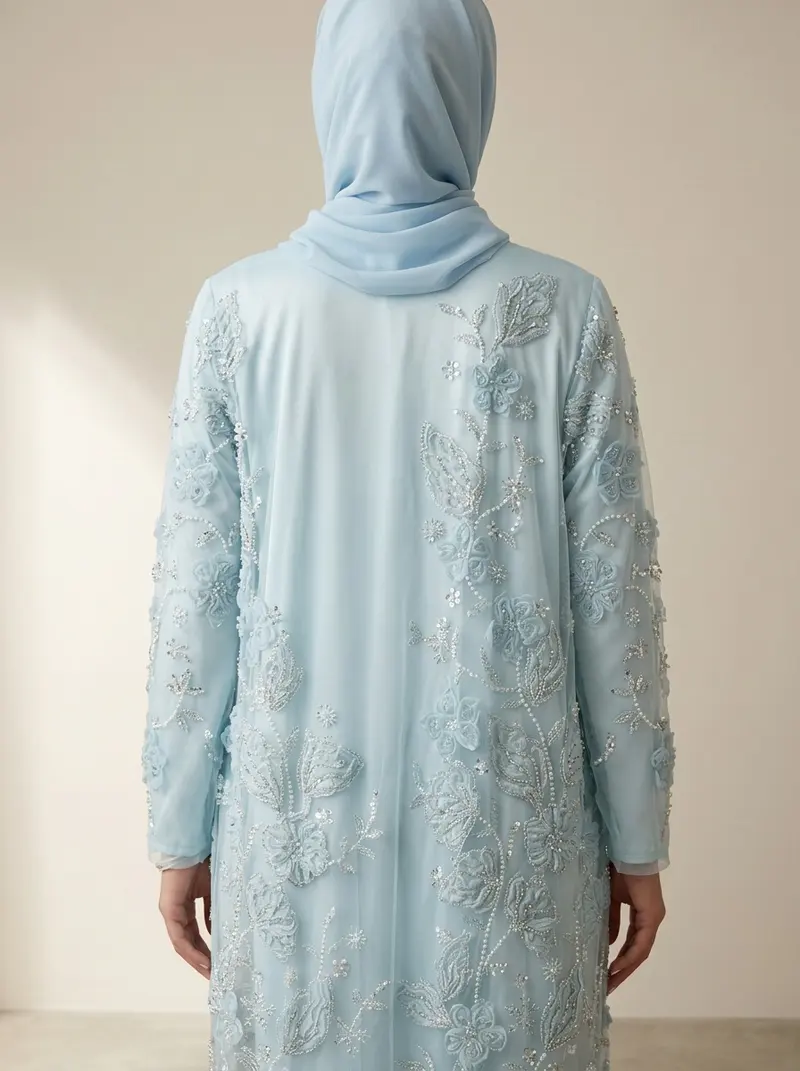 Modest Valoria powder blue abaya back view, hijab wrapped and covering the hair completely, embroidered panel visible