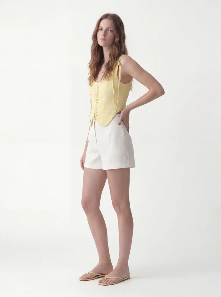 MODA AI catalog output — the vest top in butter yellow, three-quarter, same model and studio