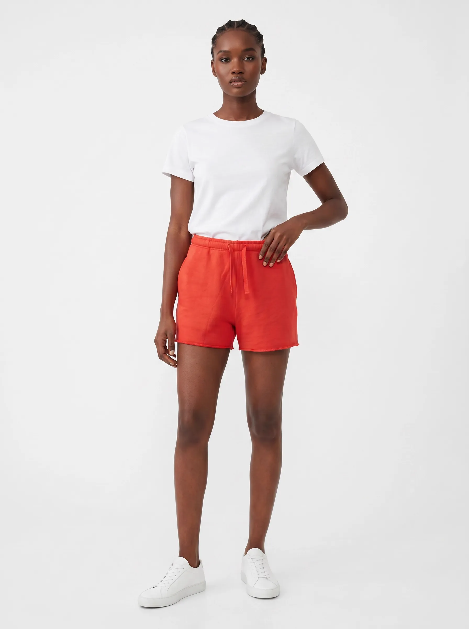 MODA AI catalog output — Black model in white tee and red sweat shorts, full body front against clean white studio backdrop, the generated catalog frame produced from the seller's iPhone input