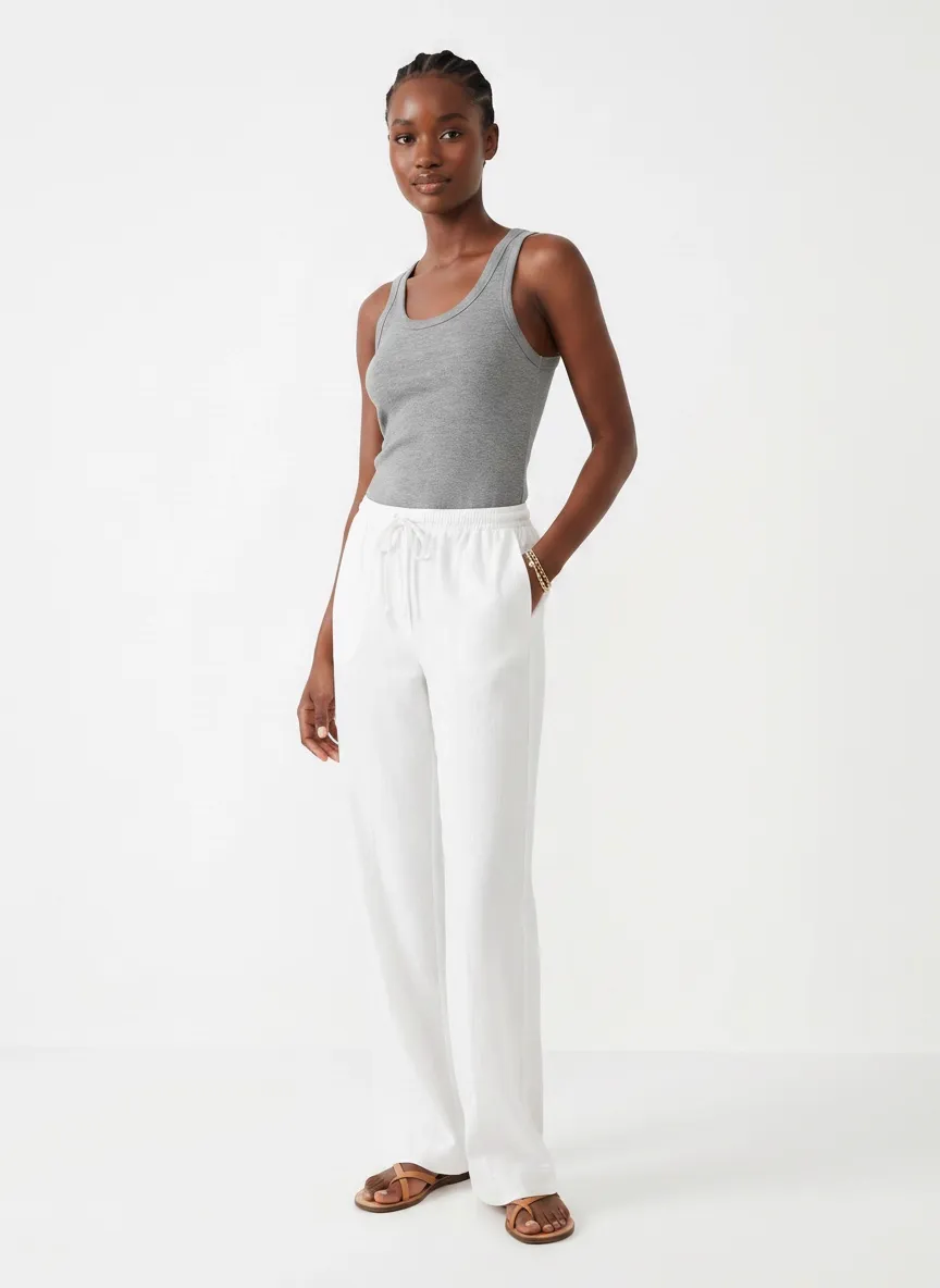 MODA AI catalog output — Black model walking in gray tank and white linen pants, dynamic catalog frame on a clean studio backdrop