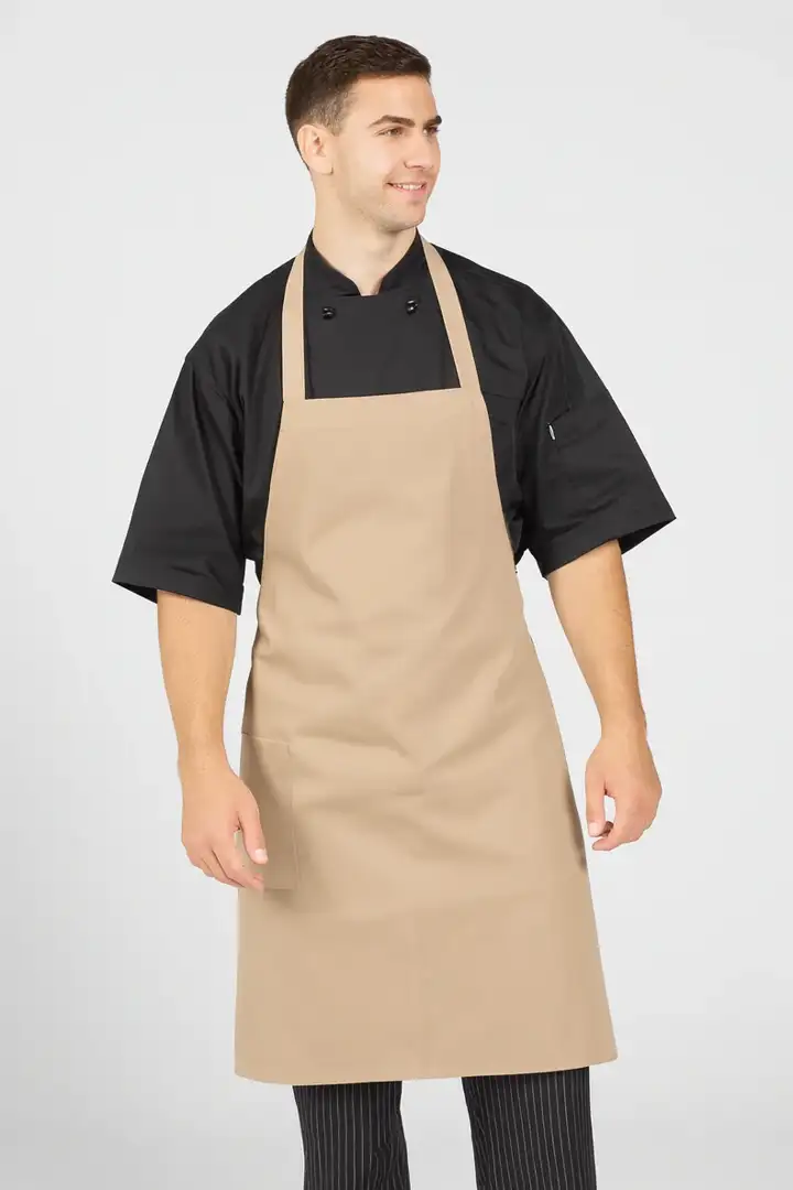 Input — tan bib apron over black short-sleeve chef coat with black-and-white pinstripe pants on a stock male model in plain studio background, the original ghost-mannequin-grade catalog photography for the uniform supplier