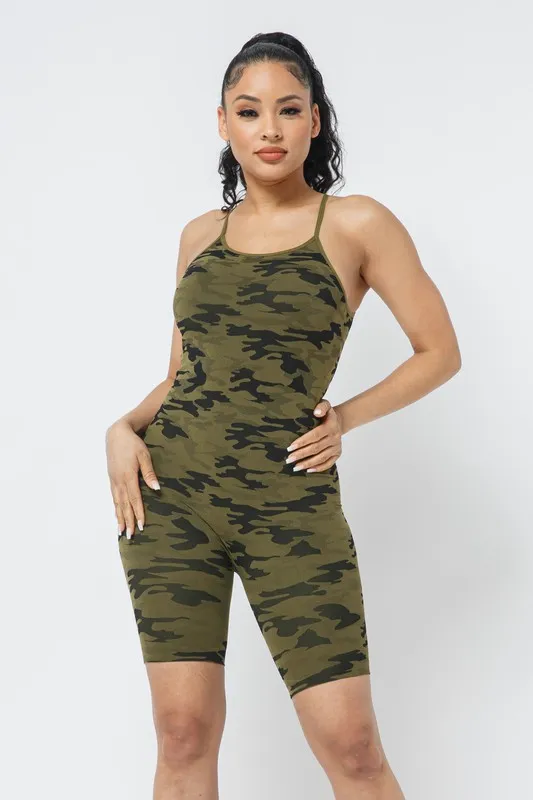 Input — brunette studio model in green camo print sleeveless bike romper against plain neutral background, the original athletic/loungewear catalog shot