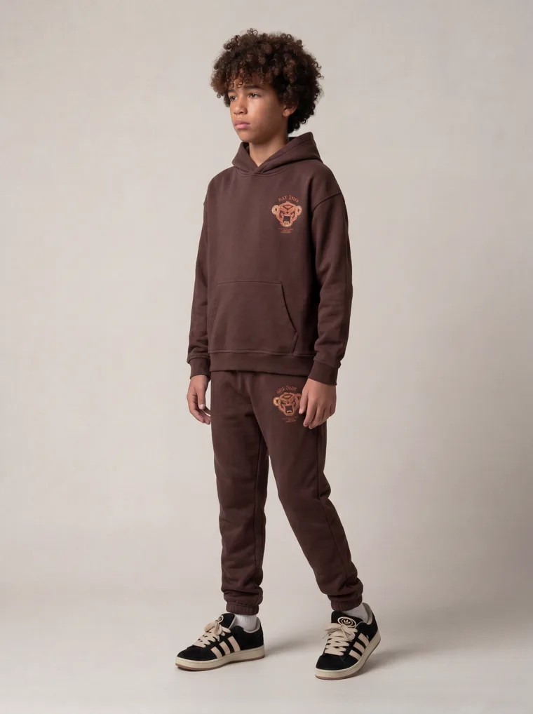 A chocolate brown kids hoodie and jogger set with a tonal animal graphic. FW26 look 20, Tonal Co-ord in Chocolate, frame 2 of 5