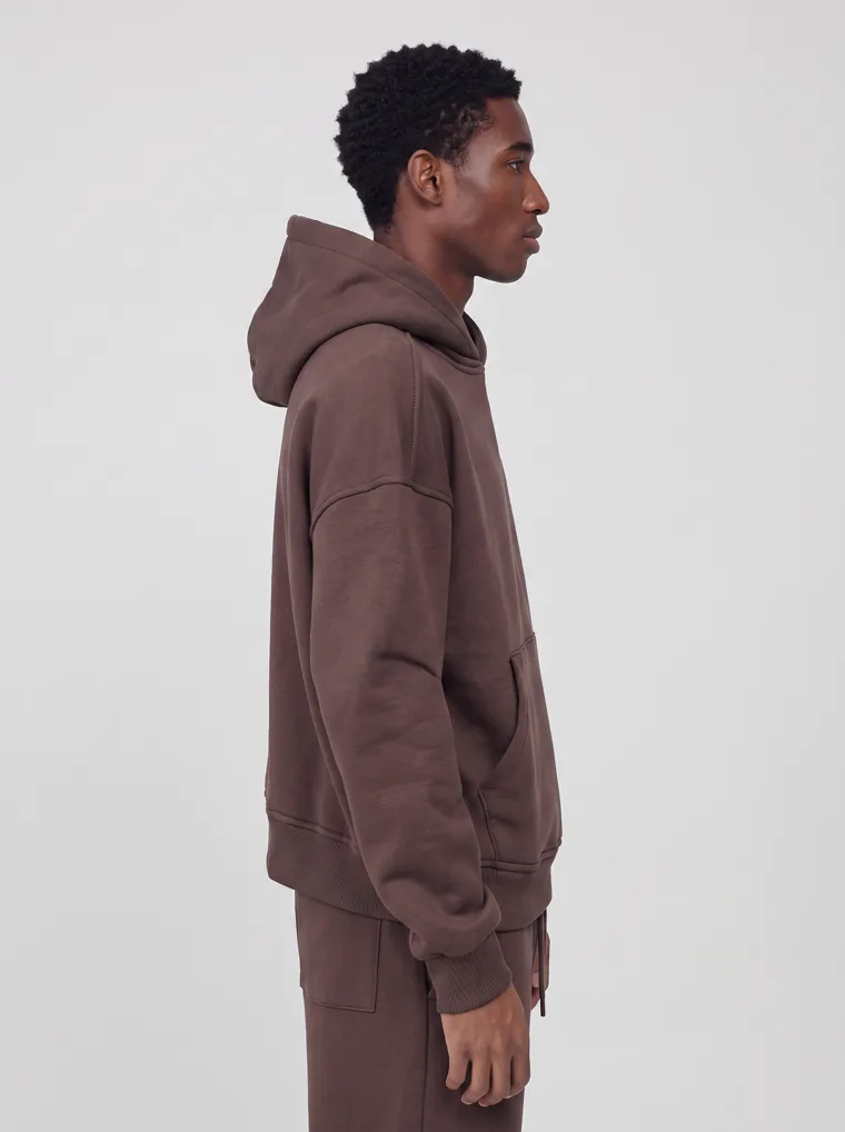 A chocolate brown hooded sweatshirt and matching sweatpants worn as a single tonal set. FW26 look 04, Tonal Set in Chocolate, frame 5 of 5