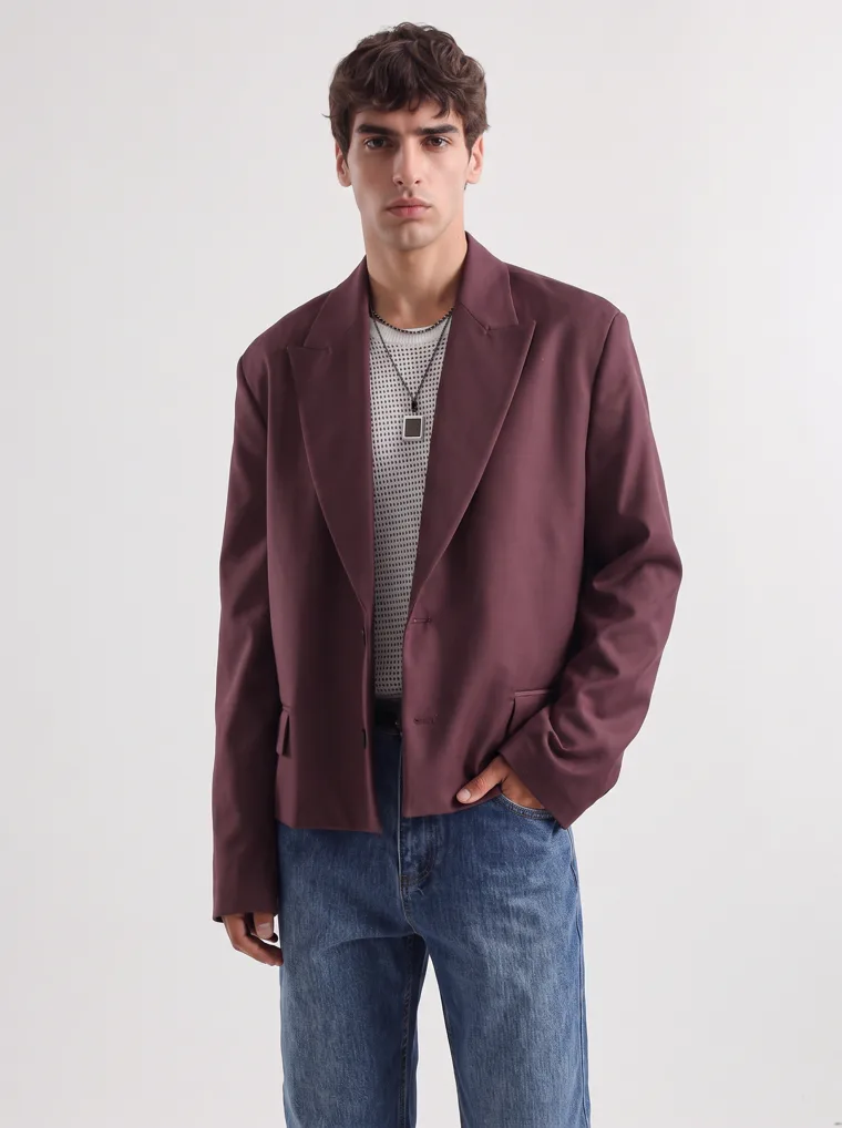 An oversized burgundy blazer over a fine striped knit with straight blue jeans and a burgundy tote. FW26 look 02, Soft Tailoring in Burgundy, frame 5 of 5