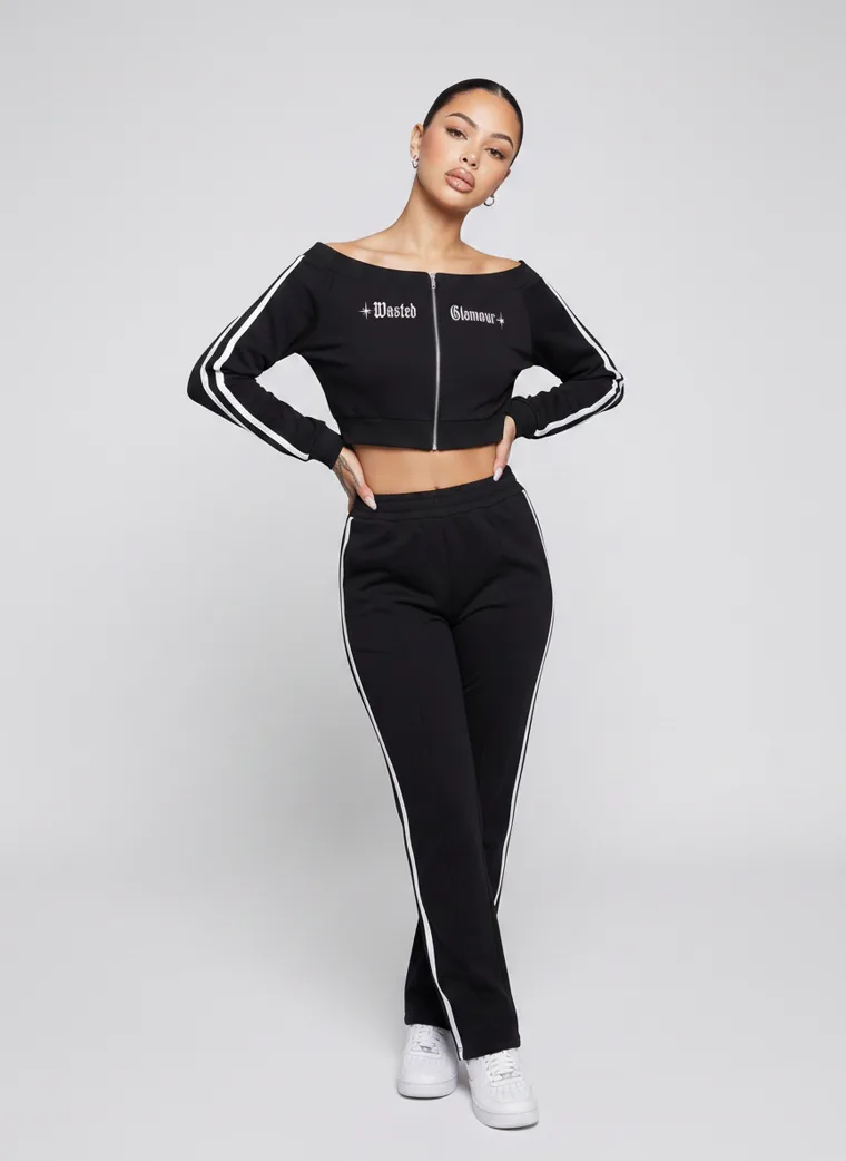 A black cropped zip track top with matching side striped track pants. FW26 look 15