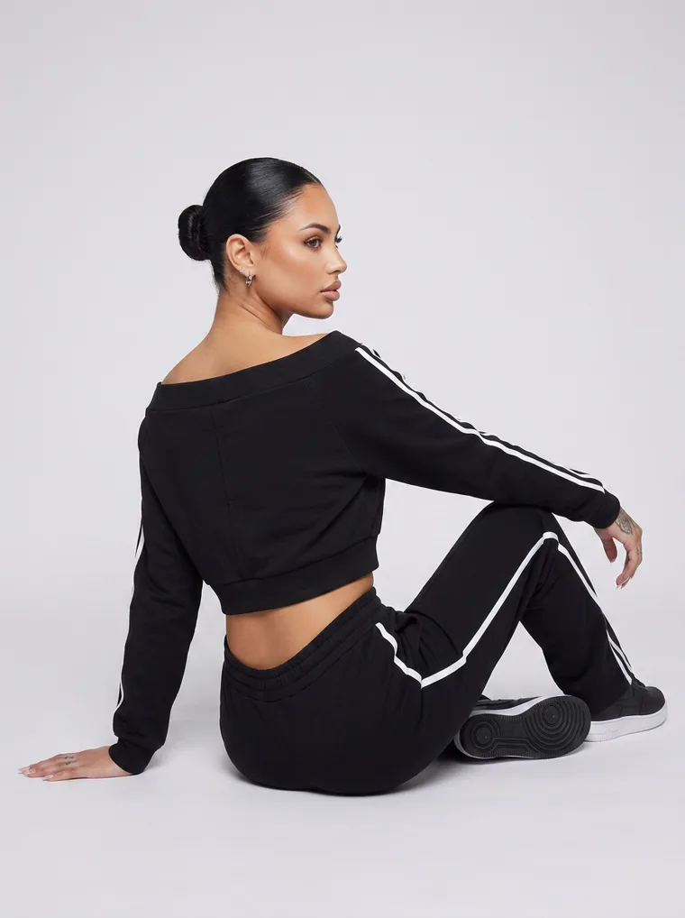 A black cropped zip track top with matching side striped track pants. FW26 look 15, Athletic Monochrome in Black, frame 3 of 5