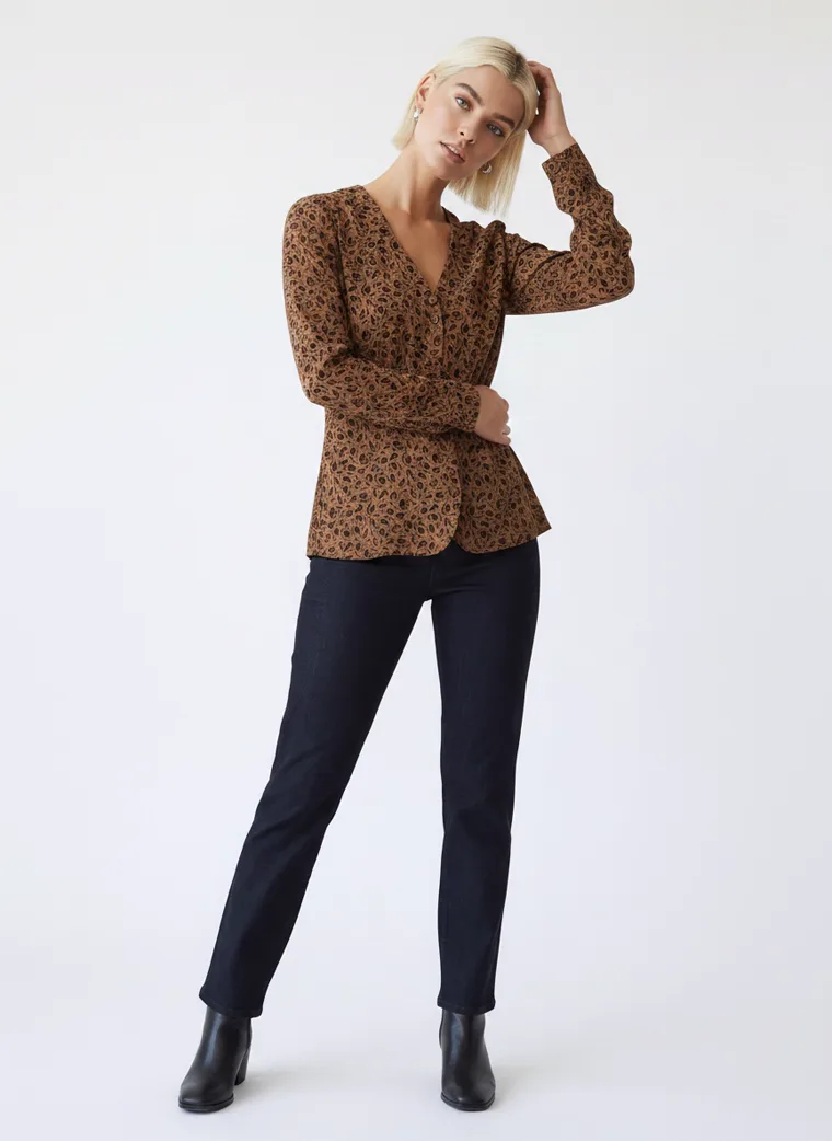 A model in a tobacco brown animal print blouse with dark indigo jeans and black ankle boots, FW26 look 10