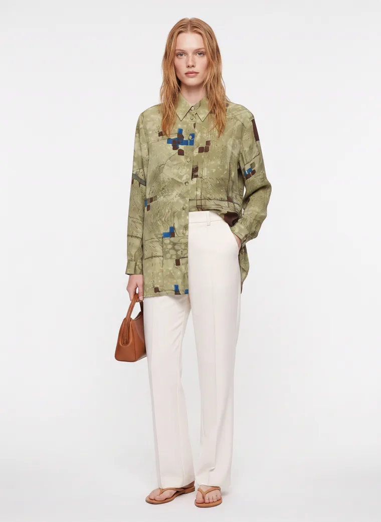 An olive abstract print oversized shirt worn open over cream wide leg trousers. FW26 look 08, Print on Ease in Olive, frame 2 of 5