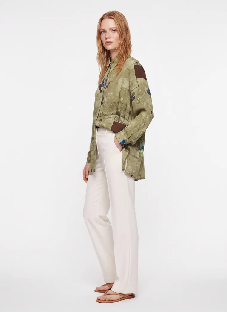 An olive abstract print oversized shirt worn open over cream wide leg trousers. FW26 look 08, Print on Ease in Olive, frame 5 of 5
