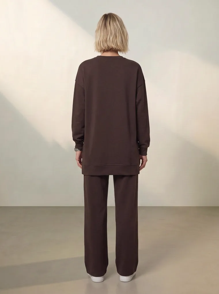 A chocolate brown sweatshirt with a cream daisy graphic and matching wide leg lounge trousers. FW26 look 12, Tonal Lounge in Chocolate, frame 4 of 5