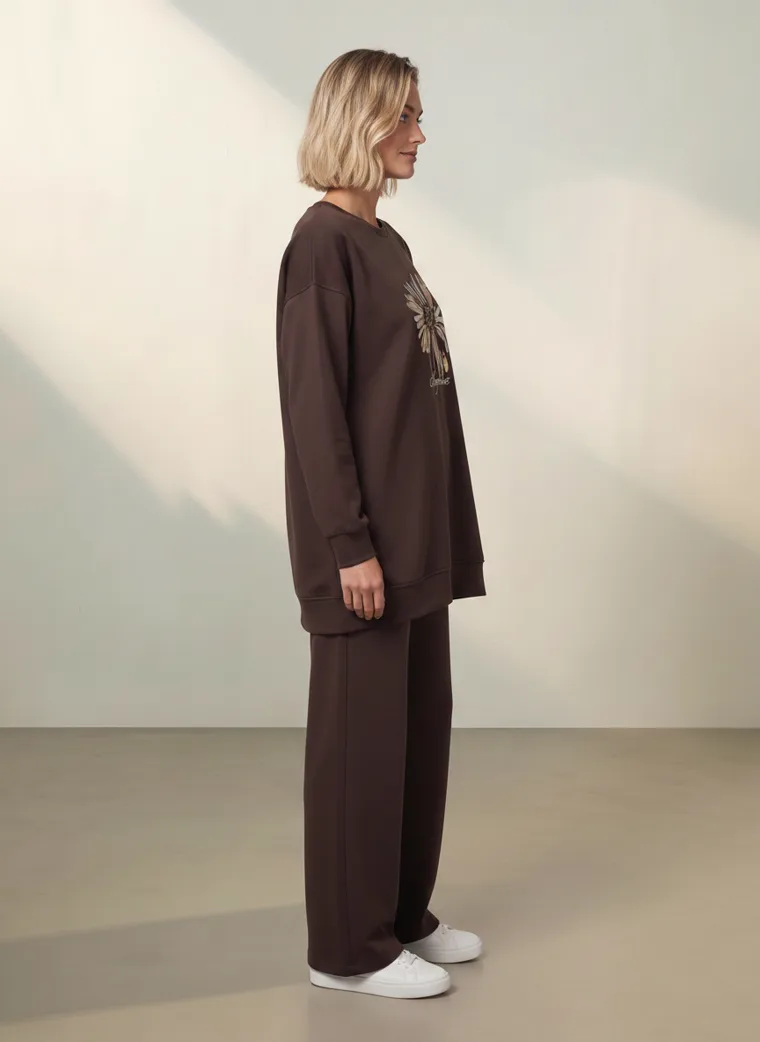 A chocolate brown sweatshirt with a cream daisy graphic and matching wide leg lounge trousers. FW26 look 12, Tonal Lounge in Chocolate, frame 5 of 5