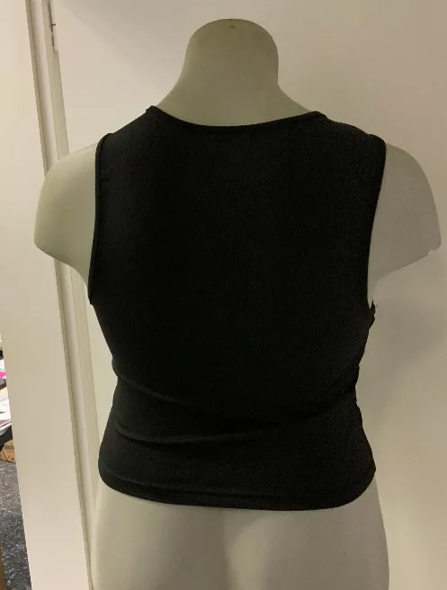 The seller’s phone photo of the studded crop top on a shop mannequin, back view
